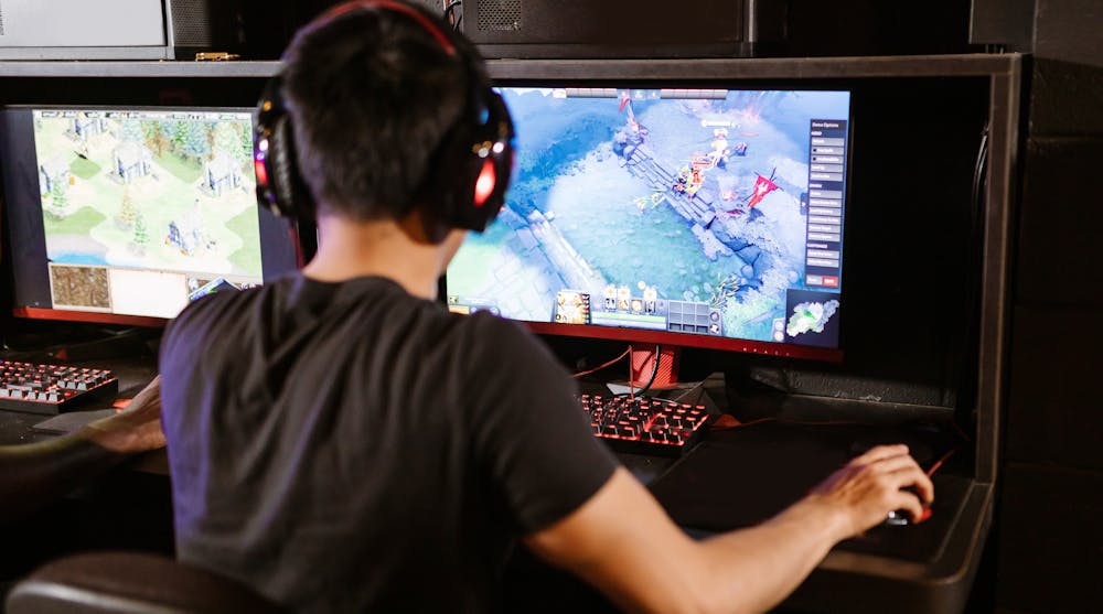 A man playing a computer game on multiple screens